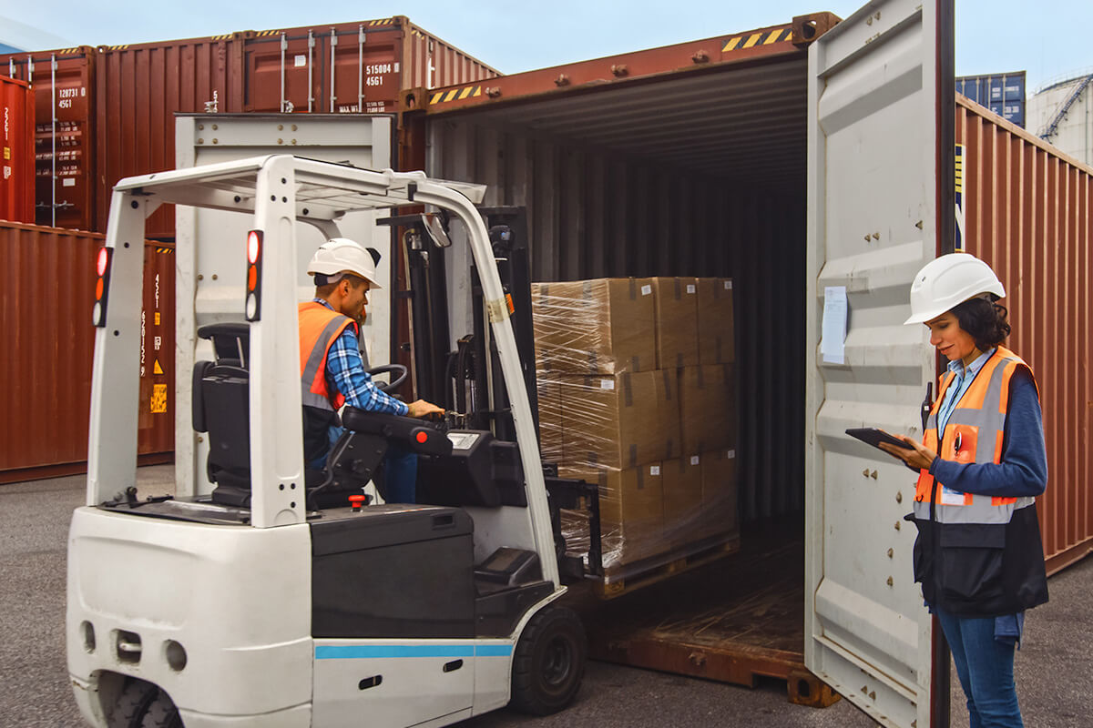 forklift employee removing goods from shipping containers