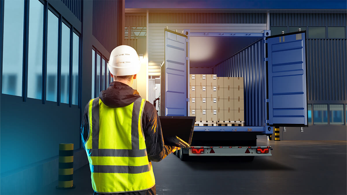 worker watching goods placed into back of truck