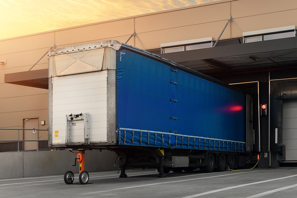 image of the backside of a freight truck inside a dock unloading goods