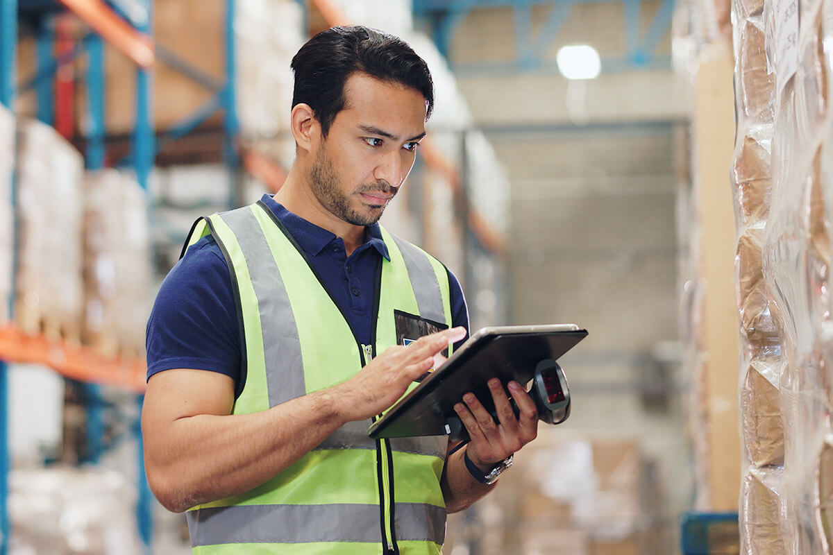Employee checking inventory with a scanner and tablet